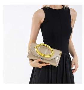 Detail of champagne gold evening clutch featuring a large oval metal handle for women