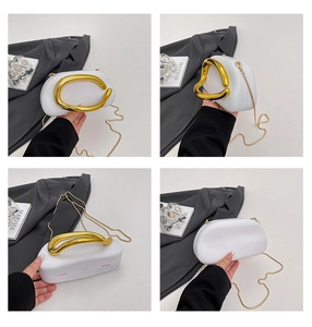 White hard shell evening bag with golden metallic handle and fine chain strap detail