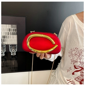 Detail of red cloud clutch bag with gold metallic handle and delicate chain strap
