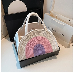Detail of a half-moon woven cotton rope handbag with pink and purple rainbow pattern