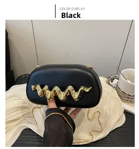 Elegant black evening clutch with gold wave handle and chain strap on white background