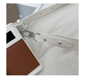 Detail of silver metal lobster clasp and contrast stitching on bi-color camera bag