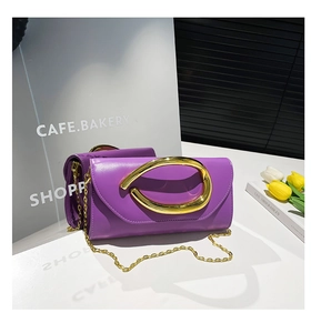 Detail of purple rectangle clutch bag with gold oval handle and chain strap