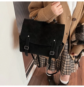 Detail of vintage matte black backpack with silver buckle straps and British college style