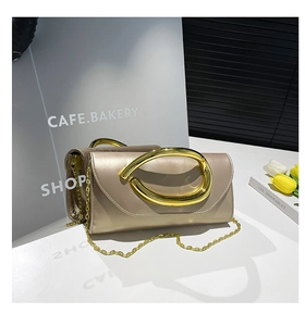 Detail of champagne gold evening clutch with satin finish and oval metal handle