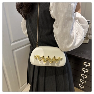 Detail shot of white wavy evening bag featuring golden metal trim and sleek chain strap