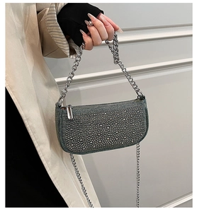 Macro view of blue denim bag with sparkling rhinestones and silver chain details