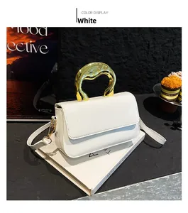 Close-up of a white glossy handbag featuring a unique wavy gold metal handle and slim strap