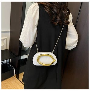Detailed view of the white semi-circle bag with a gold C-shaped buckle and metal chain