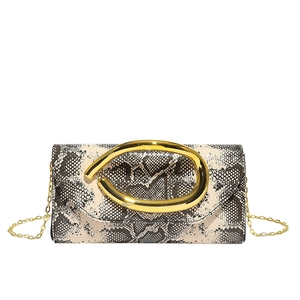 Close-up of snakeskin pattern clutch bag with gold ring buckle and delicate chain strap