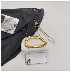 Minimalist white semi-oval handbag featuring a chunky gold metal handle and chain strap