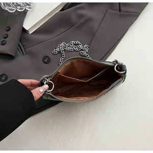 Close-up of saddle bag interior showing dark green canvas and silver chain strap