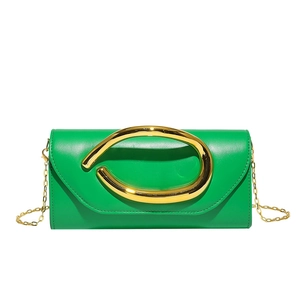 Macro shot of green leather clutch bag with signature gold ring handle and chain strap