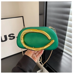 Macro view of green pearlescent evening bag with luxury gold ring clasp and chain strap