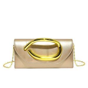 Detailed view of champagne gold evening clutch with round metal handle and chain strap