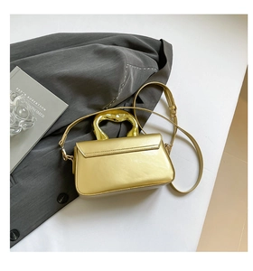Detail of gold mirror acrylic handbag with irregular liquid metal top handle and strap