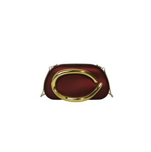 Detail of burgundy evening bag with large gold handle and detachable chain strap