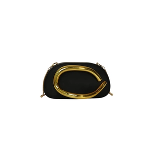 Detail of black semi-circular evening clutch with gold C-shaped metal ornament and chain