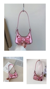 Détail macro du sac en cuir verni rose brillant avec grand nœud et finition métallique