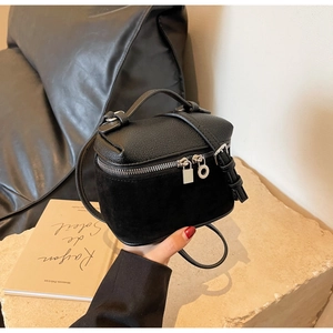 Detail of black box bag with dual textures of lychee grain and suede leather finish