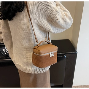 Detail of vintage brown box bag showing textured leather stitching and silver zippers