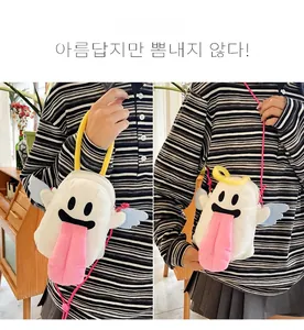Détail du sac fantôme en peluche montrant la langue rose et les ailes bleues