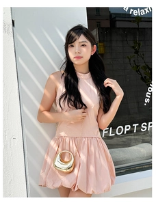Detail of a gold metallic crescent chain bag paired with a pink puff mini dress