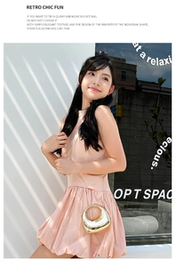 Chic gold crescent acrylic bag with metal chain strap shown on a model outdoors