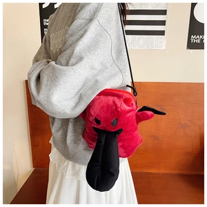 Détail du sac bandoulière clown en peluche rouge avec langue rigolote et sangle noire