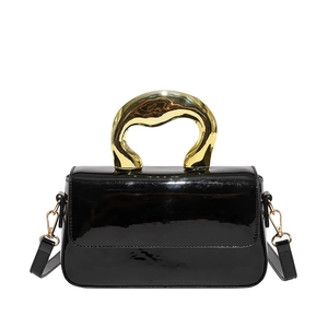 Chic black glossy patent leather crossbody bag with creative gold geometric top handle