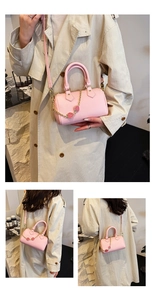 Pink lychee grain boston bag with gold strawberry charm shown in three carrying styles