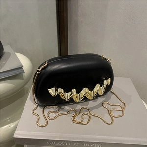 Acrylic black capsule clutch with gold wave handle and snake chain crossbody strap