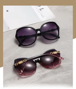 Detail of oversized sunglasses with polarized gradient lenses and gold chain temple accents