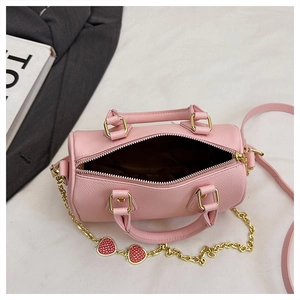Pink boston bag with strawberry charms and gold chain detail on textured leather