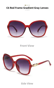 Detail of red oversized sunglasses featuring golden metal accents and gradient lenses