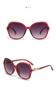 Detail of oversized purple resin sunglasses with gradient lenses and gold chain temple accents