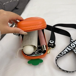 Carrot-shaped silicone crossbody bag showing capacity for phone and folding umbrella