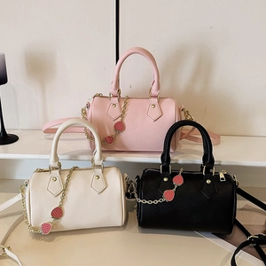 Three mini Boston style handbags in pink, white, and black with strawberry charm details