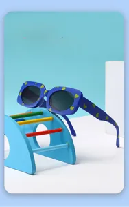 Detail view of heart-print kids sunglasses on a rainbow toy stairs background