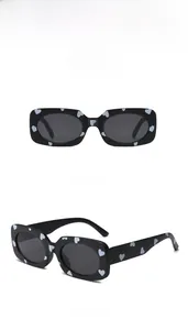Detail of children's heart print sunglasses with black square frame and grey lenses