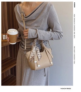 Detail of apricot lychee pattern leather bucket bag with houndstooth silk scarf handle
