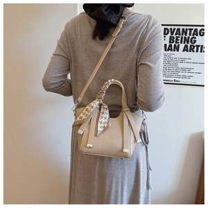 Litchi pattern beige bucket bag with metal chain handle and houndstooth scarf detail