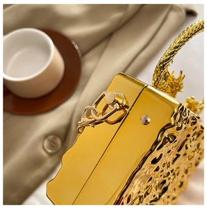 Detail of gold acrylic clutch with ice crack texture and ornate dragon scale handle