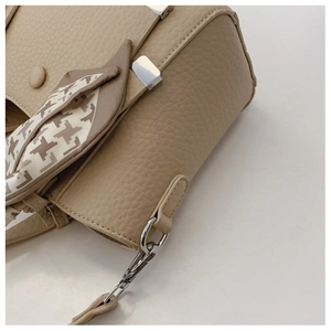 Detail of beige lychee leather handbag with silver hardware and houndscout scarf