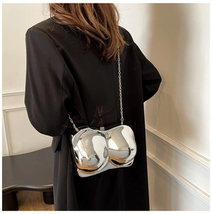 Futuristic silver bra-shaped crossbody bag with reflective mirror finish and chain strap