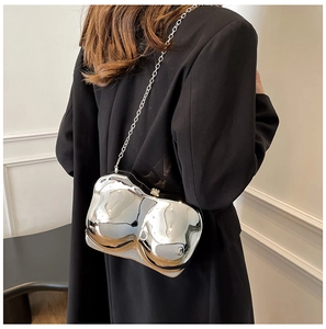 Detailed view of a silver mirror-finish female torso shaped evening bag with metal chain