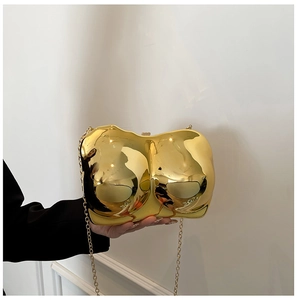 Detailed view of the gold metallic body-shaped clutch bag with polished finish and chain