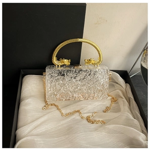 Detailed macro view of the gold double-dragon handles on ice-crack acrylic handbag