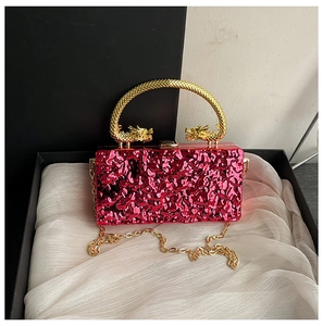 Detail of red water-ripple acrylic evening bag with gold dragon-shaped handle