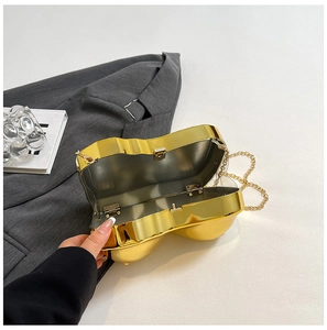 Detailed close-up of golden spherical metal clutch bag with high-shine mirror finish and chain